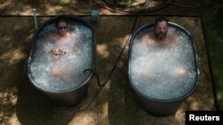 미국 텍사스주 휴스턴의 무더위 속, 체육관 내 시설에서 남성과 여성이 콜드 플런지(Cold Plunge)를 하고 있다.