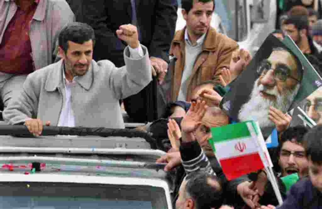 Iranian President Mahmoud Ahmadinejad, clenches his fist from his car, as he attends a rally marking the 32nd anniversary of 1979 Islamic Revolution, Feb 11, 2011