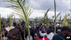 FILE —Christians walk in the Palm Sunday procession on the Mount of Olives in east Jerusalem, Sunday, March 24, 2024.