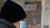 FILE - A man looks at a kiosk displaying a newspaper with a photo of Chen Xuyuan, head of the Chinese Football Association, in Beijing, Feb. 15, 2023. 