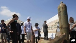 Activists and international delegations look at cluster bomb units during a visit to a Lebanese military base, Nabatiyeh, Lebanon, September 11, 2011.