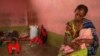 A woman sits with her wounded baby in a central Mekelle, Ethiopia, classroom that was turned into housing for displaced people, June 3, 2021. 