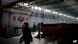 FILE - A North Korean factory worker walks through a processing hall at the Pyongyang 326 Electric Wire Factory, Jan. 10, 2017, in Pyongyang, North Korea.