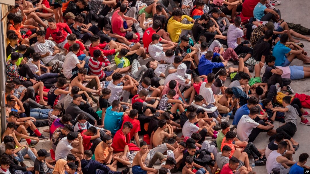 Los menores no acompañados que cruzaron a España aparecen reunidos afuera de un almacén utilizado como refugio temporal en el enclave español de Ceuta, cerca de la frontera entre Marruecos y España, el miércoles 19 de mayo de 2021.