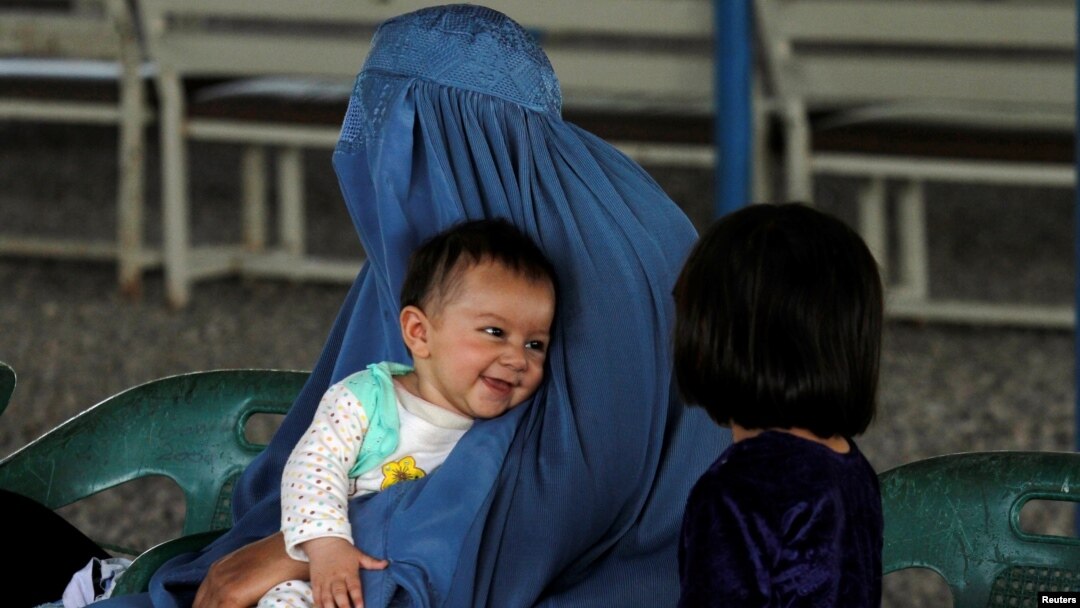 An Afghan refugee woman waits with her children to be repatriated to Afghanistan, at the United Nations High Commissioner for Refugees office on the outskirts of Peshawar, Pakistan, April 3, 2017. 