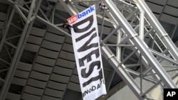 Protesters against the Dakota Access Pipeline rappel from the catwalk in U.S. Bank Stadium during the first half of an NFL football game between the Minnesota Vikings and the Chicago Bears, Jan. 1, 2017, in Minneapolis. 