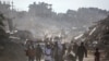 Palestinians carry belongings amidst building rubble in a ruined neighborhood of Gaza's southern city of Rafah on Jan. 20, 2025, as residents return following a ceasefire deal a day earlier between Israel and the Palestinian Hamas group.