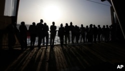 FILE - African migrants look at the Mediterranean Sea as they await disembarkation at the port of Augusta, on the island of Sicily, Italy, Sept. 27, 2021. 