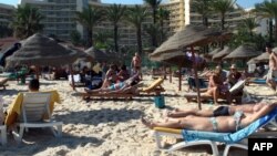 FILE - Tourists enjoying the beach near a four-star hotel in the resort town of Sousse, a popular tourist destination south of the Tunisian capital.