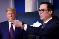 FILE - President Donald Trump listens as Treasury Secretary Steven Mnuchin speaks about the coronavirus at the White House, April 2, 2020, in Washington.