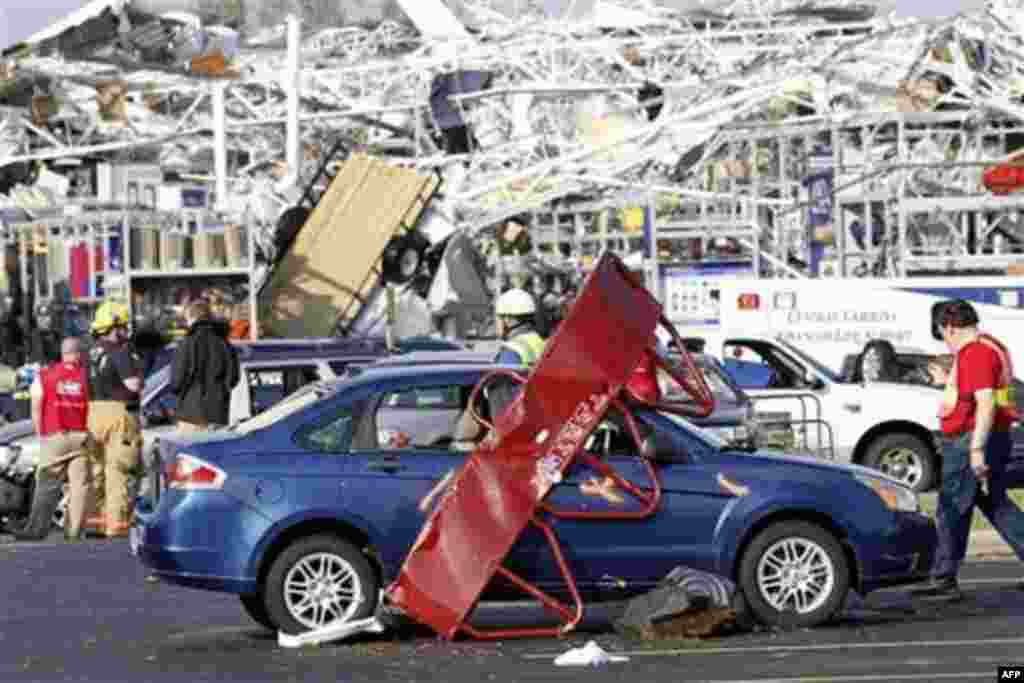 Emergency personnel work around a Lowes Home Improvement store after it was hit by a tornado in Sanford, North Carolina, April 16, 2011