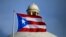 FILE - The Puerto Rican flag flies in front of Puerto Rico's Capitol as in San Juan, Puerto Rico, July 29, 2015.
