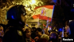 Seorang pengunjuk rasa mengacungkan salib di tengah unjuk rasa memprotes amnesti yang diberikan kepada kelompok separatis Catalan, di Madrid, Spanyol, Minggu, 12 November 2023. (Foto: Susana Vera/Reuters)