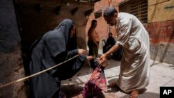 Stanovnici Bagdada rashlađuju dijete zbog talasa vrućina (Foto: AP/Hadi Mizban)