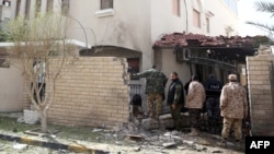 Libyan security forces inspect the site of a bomb explosion at the entrance of the residence of the Iranian ambassador in the capital Tripoli, Feb. 22, 2015.