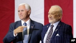 Wakil Presiden Mike Pence (kiri) menunjuk astronot Apollo 11, Buzz Aldrin, dalam acara peringatan di Kennedy Space Center untuk memperingati misi Apollo 11, Sabtu, 20 Juli 2019, di Cape Canaveral, Florida. (Foto: John Raoux/AP)