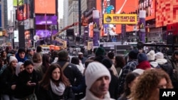 FILE - Tourists walk in Times Square on December 30, 2024, as preparations are underway for the New Year's celebration in New York City.