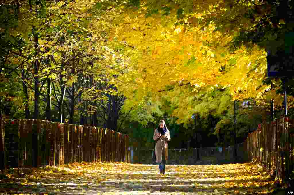 Seorang perempuan berjalan di sebuah taman di Vorobyovy Hills, di Moskow, Rusia Rabu 6 Oktober 2021. (Foto: AFP)