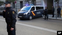 Spanish national police officers stand guard as a police van arrives at the Supreme Court in Madrid, Dec. 1, 2017.