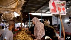 FILE - A vegetable vendor sells produce at a market in Cairo, Egypt, Jan. 10, 2017.