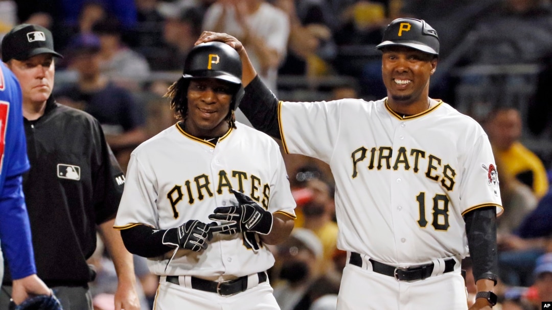 Pittsburgh Pirates' Gift Ngoepe, a native of South Africa, and the first baseball player from the continent of Africa to play in the Major Leagues celebrates with first base coach Kimera Bartee (18) after getting a single off Chicago Cubs starting pitcher