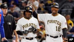 Pittsburgh Pirates' Gift Ngoepe, a native of South Africa, and the first baseball player from the continent of Africa to play in the Major Leagues celebrates with first base coach Kimera Bartee (18) after getting a single off Chicago Cubs starting pitcher