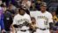 Pittsburgh Pirates' Gift Ngoepe, a native of South Africa, and the first baseball player from the continent of Africa to play in the Major Leagues celebrates with first base coach Kimera Bartee (18) after getting a single off Chicago Cubs starting pitcher