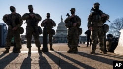 National Guard troops and members of the U.S. Capitol Police keep watch as security remains high on Capitol grounds following the Jan. 6 attack by supporters of then-President Donald Trump, in Washington, March 3, 2021.