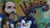 ARCHIVO - Un peatón pasa junto a un mural dedicado a los héroes que presenta al presidente Nayib Bukele en el barrio Soyapango de San Salvador, El Salvador, el 28 de febrero de 2023.