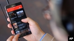 FILE - The YouTube Music app is displayed on a mobile phone in Los Angeles, Nov. 13, 2015.