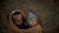 Pakistani Ibrahim Mohammed, 42, who was displaced with his family from Pakistan's tribal region of Mohmand Agency due to fighting between the Taliban and the army, wraps himself and his son Mashal, 1, with a shawl to avoid the evening cold, while sitting in front of his home in a poor neighborhood on the outskirts of Islamabad.