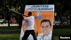 Un miembro del Frente Lucha Nacional (FNL), destruye un cartel de la campaña electoral donde aparecen Otto Pérez y Alejandro Sinibaldi durante una manifestación en Ciudad de Guatemala el 7 de septiembre de 2011. 