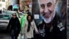 تہران میں دو خواتین امریکی ڈرون حملے میں ہلاک ہونے والے القدس فورس کے جنرل قاسم سلیمانی کے پوسٹر کے پاس سے گزر رہی ہیں۔ اس کے جواب میں ایران نے عراق میں امریکی فوجی اڈوں کو نشانہ بنایا تھا۔ 