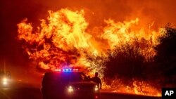 Flames lick above vehicles on Highway 162 as the Bear Fire burns in Oroville, Calif., Sept. 9, 2020. 