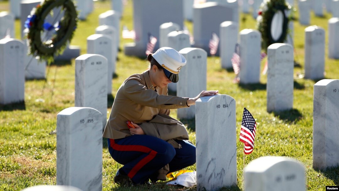 Seorang anggota marinir AS memberikan penghormatan dengan menyentuh batu nisan pada makam rekannya yang dimakamkan di Taman Makam Pahlawan di Arlington, Virginia (Foto: dok).