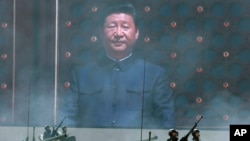 习近平的巨幅照片出现在北京纪念中国人民抗日战争暨世界反法西斯战争胜利70周年大会上。（2015年9月）