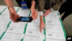 ARCHIVO - En esta fotografía de archivo del 6 de noviembre de 2020, un supervisor de escrutinio fotografía papeletas provisionales en el condado Lehigh mientras prosigue el conteo de votos de la elección general en Allentown, Pensilvania. 