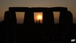 FILE - Revelers gather at the ancient stone circle Stonehenge to celebrate the Summer Solstice, the longest day of the year, near Salisbury, England, Wednesday, June 21, 2023. (AP Photo/Kin Cheung, File)