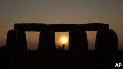 ARCHIVO: Un grupo de personas celebran el solsticio de verano en el círculo de piedra milenario de Stonehenge, en Inglaterra, el 21 de junio de 2023.