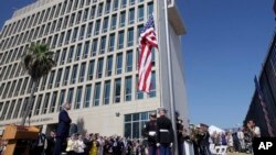 FILE - Officials watch the raising of the American flag at the newly opened U.S. Embassy in Havana, Cuba, Aug. 14, 2015. 