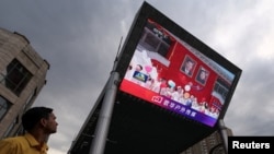在中国北京某购物区，一名男子正注视着巨型屏幕上播放的新闻画面，画面显示中国国家主席习近平在平壤出席朝鲜领导人金正恩为他举行的欢迎仪式。(2026年6月8日)