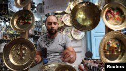 FILE - An artisan works on bronze plates in the Medina, in the old city of Tunis, Tunisia September 14, 2019. (REUTERS/Muhammad Hamed)