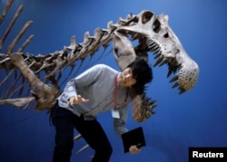 Poziranje pored replike skeleta Spinosaurusa u Tokiju. (Foto: REUTERS/Yuya Shino)