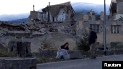 Warga berdiri di pinggir jalan menyusul gempa yang melanda kota Amatrice, Italia tengah (24/8). (Reuters/Emiliano Grillotti)