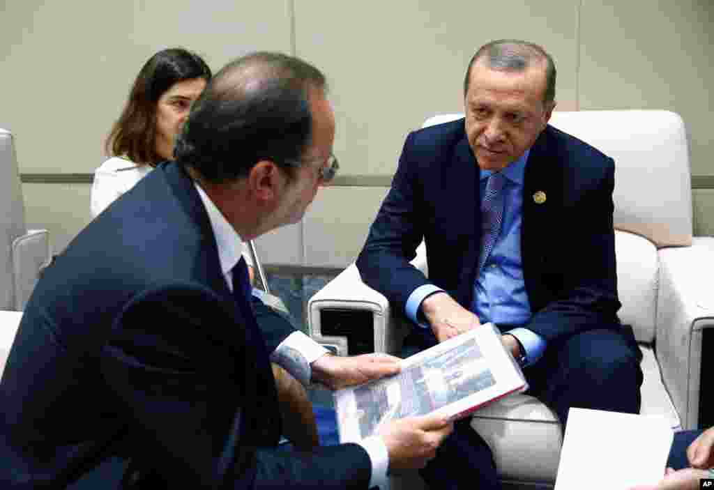 Presiden Tukri Recep Tayyip Erdogan (kanan) mendengarkan Presiden Perancis Francois Hollande dalam pertemuan bilateral di sela-sela KTT G20 di Hangzhou, provinsi Zhejiang, China (5/9).