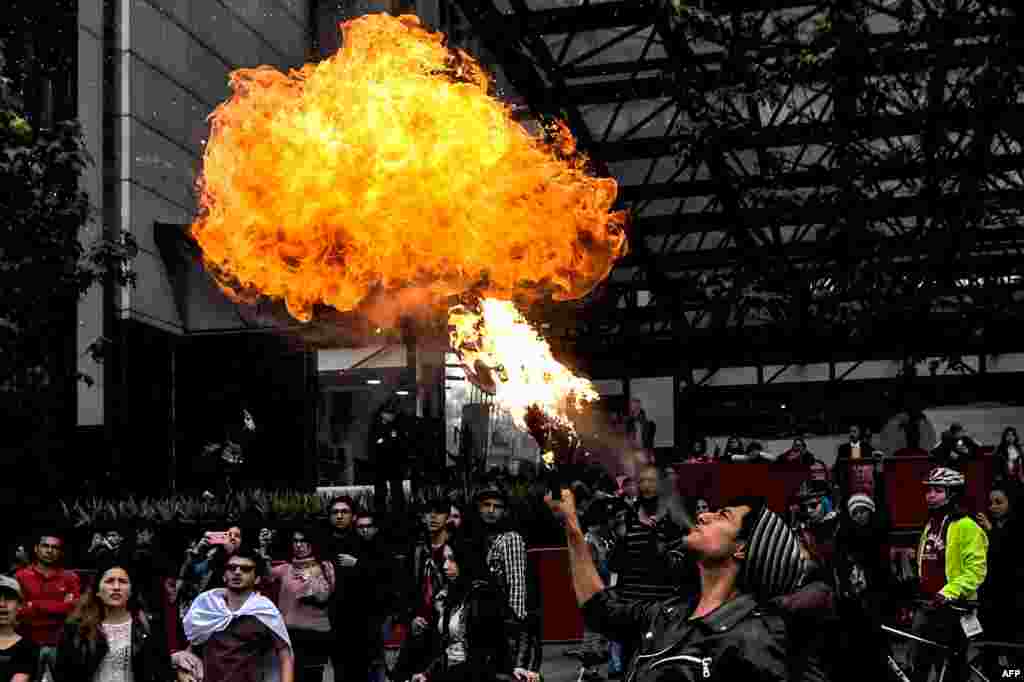 A student spits fire during a protest for Dilan Cruz, a young demonstrator who had been wounded later died during a protest against the Colombian government, in Bogota, Nov. 26, 2019.