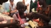 A South Sudanese nurse talks to a malnourished internally displaced orphan girl in the hospital run by Medecins Sans Frontieres (MSF) inside the camp for IDPs in Malakal, Upper Nile State, May 29, 2014. 