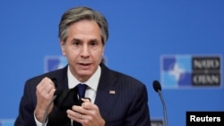 FILE - U.S. Secretary of State Antony Blinken removes his mask as gives a press briefing at the end of a NATO Foreign Ministers' meeting at the Alliance's headquarters in Brussels, Belgium, March 24, 2021.