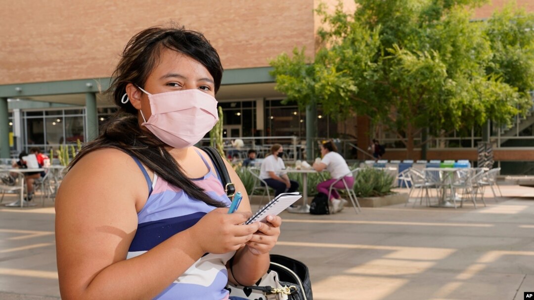 Arizona State University political science major Betzabel Ayala poses for a photo on campus Sept. 8, 2020, in Tempe, Ariz. Experts warn that coronavirus cases are surging among young adults in the US. 