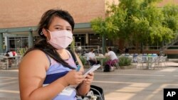 Arizona State University political science major Betzabel Ayala poses for a photo on campus Sept. 8, 2020, in Tempe, Ariz. Experts warn that coronavirus cases are surging among young adults in the US. 